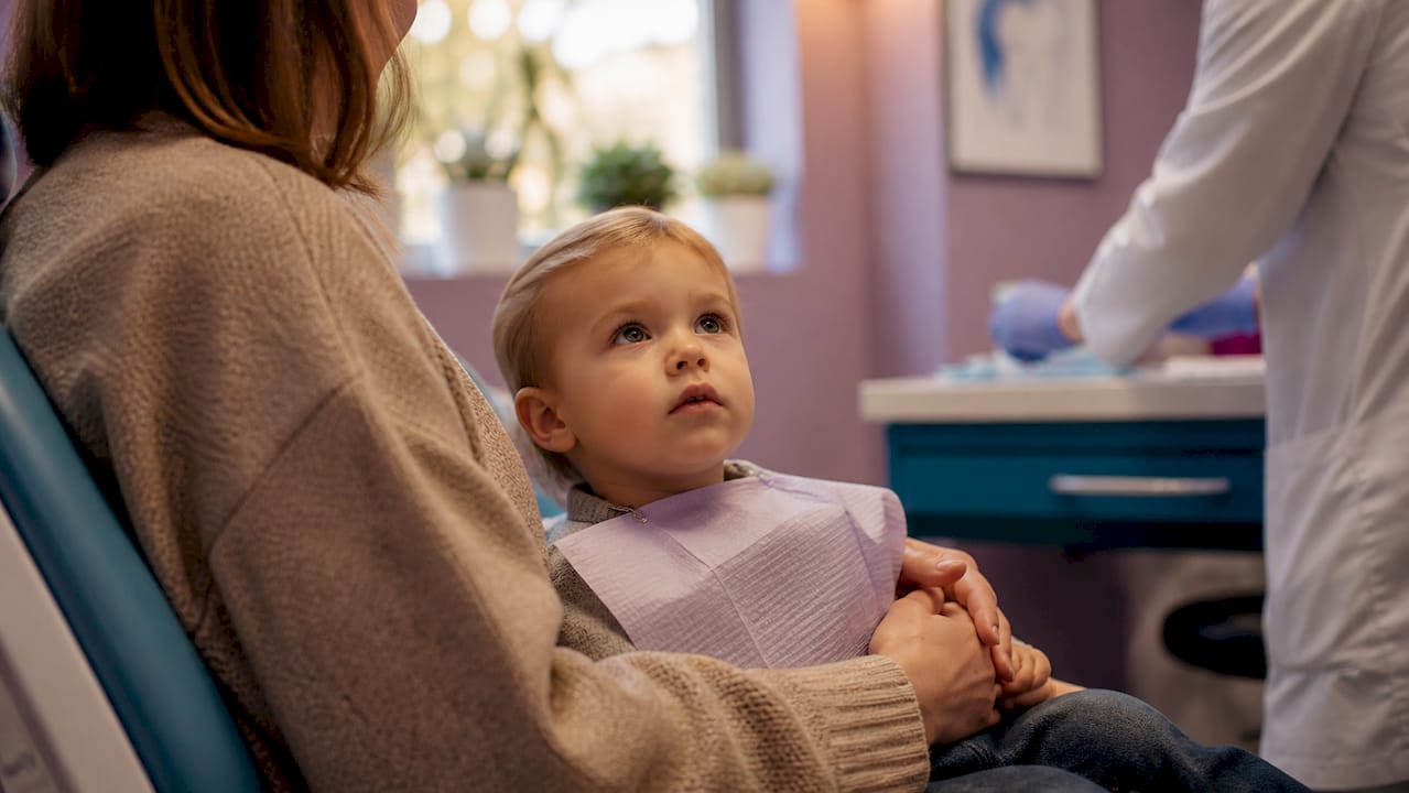 Parent holding child during dental visit