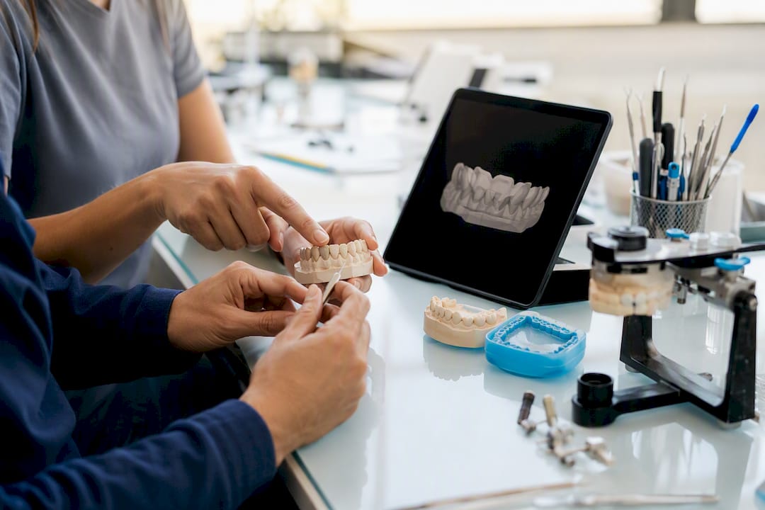 Hands coordinating dental models and tablet